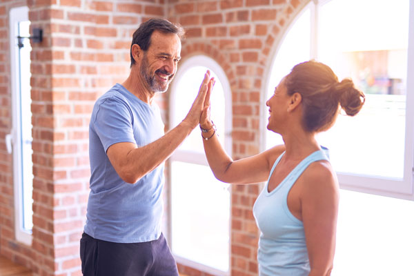 Middle Aged Couple High Fiving After Workout